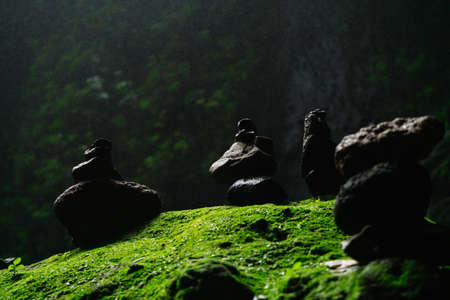 Balancing stones tower on mossy stone backgroundの写真素材