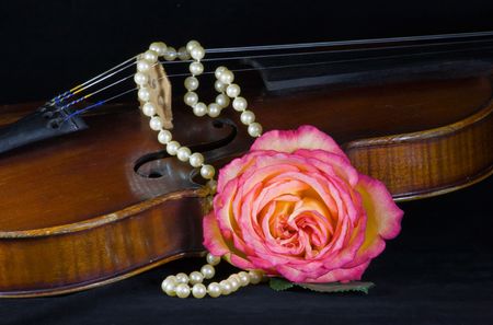 Closeup of old violin, rose and string of pearlsの写真素材