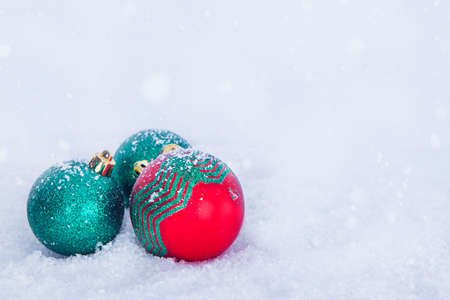 Christmas greeting background, red and cyan balls on white snowの写真素材
