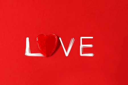 Heart red lollipop on the red background. Valentines day greeting card. High quality photo