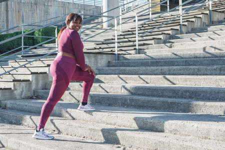Young black woman exercising, running up steps. High quality photo