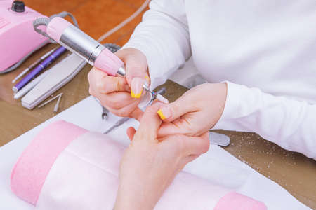 Manicurist removes nail polish uses the electric machine of the nail . High quality photoの写真素材