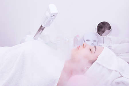 Beauty treatment of face with ozone facial steamer in beauty center. . High quality photoの写真素材