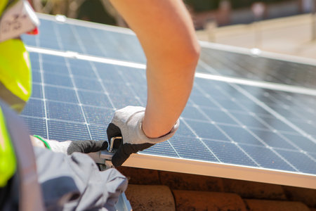 Close up of man technician in work gloves installing stand-alone photovoltaic solar panelの写真素材