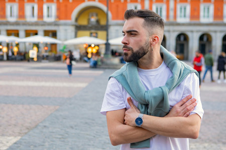 guy in his 30s, looking to the side, is strolling through the city. High quality photosの写真素材