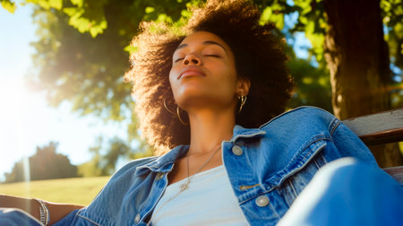 woman sitting on a park bench, she is enjoying the sun hitting her faceの素材