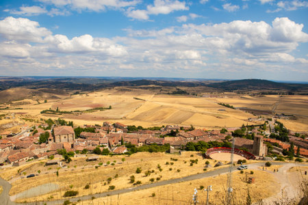 A picturesque view of the rolling hills surrounding Atienza, Spain shows ancient ruins and grassy terrain under a bright sky, perfect for outdoor exploration and photography.の写真素材