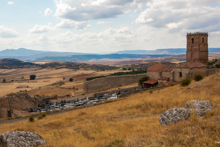 Atienza in Guadalajara features stunning medieval architecture against a backdrop of rolling hills. Visitors enjoy exploring the historic site under a clear sky with dynamic clouds.の写真素材