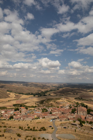 A picturesque view of the rolling hills surrounding Atienza, Guadalajara, Spain shows grassy terrain under a bright sky, perfect for outdoor exploration and photography.の写真素材