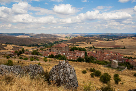 Wide view of the beautiful countryside in Atienza, Guadalajara, Spain, showing rolling hills and expansive fields beneath a partly cloudy sky during a sunny day.の写真素材