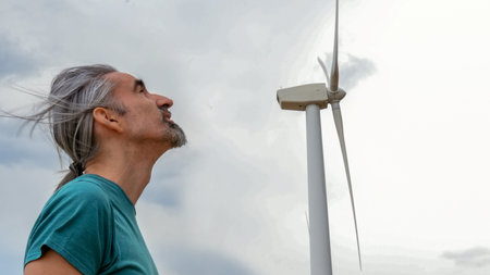 Man looking at wind turbine in the wind farm.