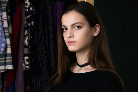 The girl at the mirror does makeup and hairstyle. The girl chooses an image.の写真素材