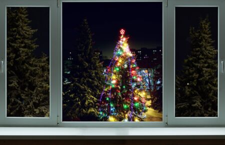 Outside the window a tree in flames among the other treesの写真素材