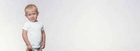 A stylish boy standing and looking arrogantly and contemptuously. Toddler ideal for website header...