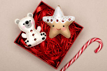 handmade star and bear of felt in a gift box with red tinsel