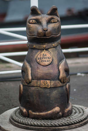 KRONSTADT, RUSSIA - 25 AUGUST 2017, A friendly sculpture of a dog made of wood, painted bronze, on a navy pier at the city. On the dog a medal with the inscription - for faithful service.のeditorial素材