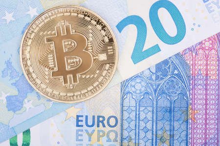 Bitcoin gold coin lies on paper euro, top view. For articles on the course of cryptocurrencies and...