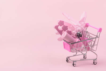 In the toy trolley from the supermarket are tools for processing nails and manicure. Concept on a pink background with place for text and advertising.の写真素材