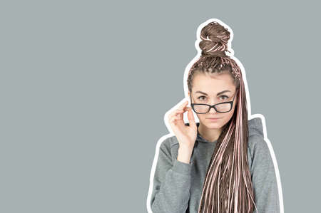 Beautiful strict girl with pink pigtails zizi lowered her glasses and looks behind them at the...
