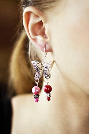 Handmade earrings hanging on the girl's earの写真素材