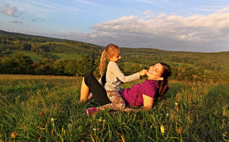 Mother and daughter relax on the meadowの写真素材