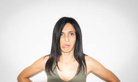 Close up of caucasian woman funny face showing tongue confidently looking straight. Woman silly aggresive portrait concept.の写真素材