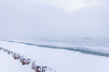 Snowing on the beach with a rough sea in the background.Snowy conitions by the sea in TAdzikidziri beach, Batumi, Sakartvelo.の写真素材