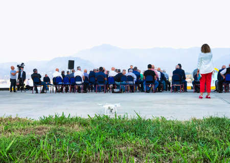 17th of october, Batumi, Georgia. Group of people sitting on the chairs outside in public event with...