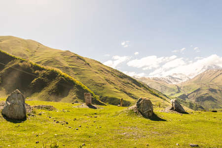 Engraved faces on the rocks on display in Kazbegi national park surounded by mountains Artists in...