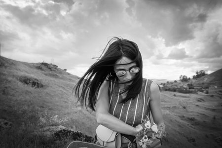 Woman with glasses hold flower bouquet nature with sky backgroundの写真素材