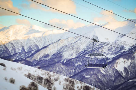 Gudauri six seat blue chair lift with caucasus mountains background. Blank space ski resort closure conceptの写真素材