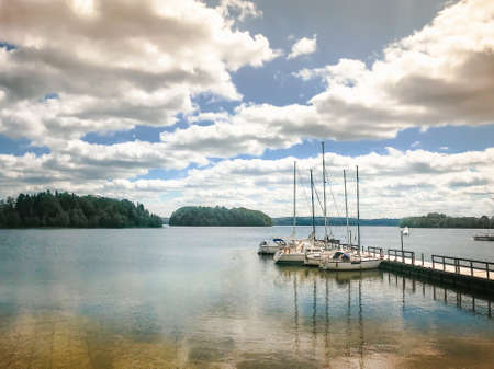 Tranquil lake panorama with boats in Lithuania countryside. Pristine nature in baltics.の写真素材