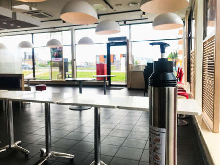 Sanitizer standing in cafe before take away orders only with no sitting allowed.