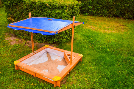 Hand made wooden sand box house for child to play with roof top in sunny hot daysの写真素材