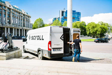 Tbilisi, Georgia - 30th april, 2022: scroll van stand by sidewalk with person collecting scroll scooter to charge. Public transportation in capital Tbilisiのeditorial素材