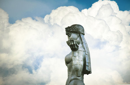 Aerial zoom out of Mother of Tbilisi, Georgia - 30th april, 2022: famous landmark Georgia statue in Tbilisi with clouds background in sunny dayのeditorial素材