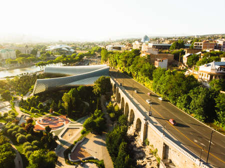 Tbilisi, Georgia - 16th june, 2022: Aerial rising view Tbilisi panorama with traffic, modern Rike...