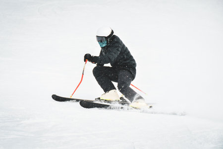 Professional skier at full speed ski downhill on fresh snow do carving in ski resort while training for competition in Gudauri ski resort in Georgiaの写真素材