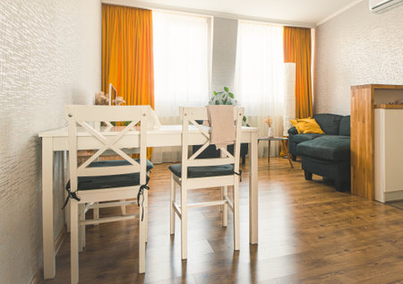 Cozy studio apartment kitchen with table sofa and bright interior autumn color paletteの写真素材