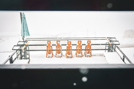 Chairs on snow in snowy day in ski resort restaurant. Bad weather fresh snow in winter holiday...