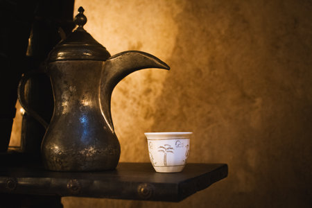 Dubai, UAE - 12th october, 2022: side view coffee set up of one white tea cup with traditional arabic dallah in coffee museum Dubaiのeditorial素材