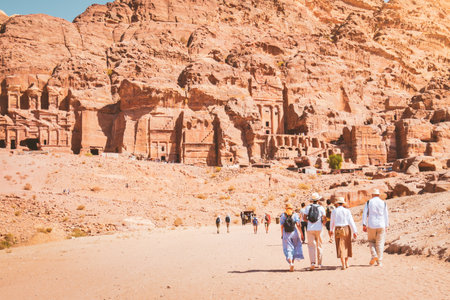 Group of friends couple tourist walk by caves of tombs in ancient city of Petra, Jordan.の写真素材