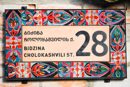 Brick wall with stylish ornamental house number and street name sign in old town Telavi. Bidzina Cholokashvili street of historical old houses.Georgian Heritage site in Kakhetiのeditorial素材