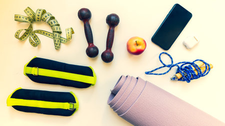 Top view Healthy female flat lay runners sports set up and fitness equipments with yoga mat isolated...