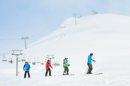 Gudauri, Georgia - 24th january, 2022: Caucasian male ski instructor teaching to ski family two kids and father beginner skier in Gudauri ski resort. Ski holiday in Georgia