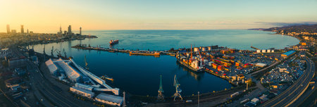 Aerial view freight transportation in Batumi with Railway and highway with cars; port panorama and waterfront promenade with sunset over horizon skyscrapers. Georgiaの写真素材