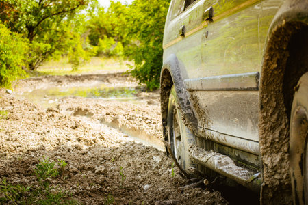 Close up view 4wd drive wheel spins through mud isolated stuck on adventure tour outdoorsの写真素材