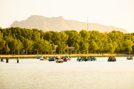 Esfahan, Iran - 15th may, 2022: muslim families enjoy boat ride on river by famous Khajoo bridge in Isfahan. Popular attraction and leisure in Iranのeditorial素材