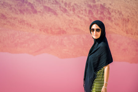 Caucasian woman tourist stand on Maharlu pink salt lake shore with reflections. Travel destination Iran in Shirazの写真素材