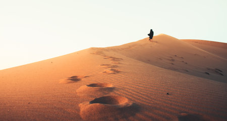 female figure in black long dress barefoot follow walk reach top on KAshan desertの写真素材